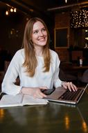 photo of happy female student with laptop and abstract in cafe