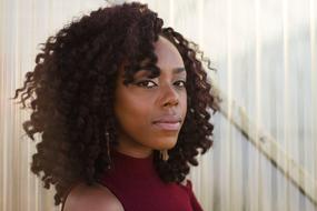 Portrait of the beautiful girl with curly hair and earrings