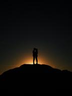 silhouettes of a couple in love with a kiss at sunset