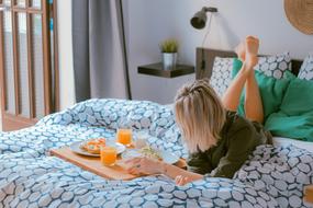 young Woman eating Breakfast in bed