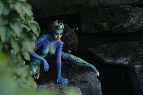 girl in a snake costume on the rocks