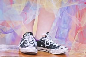 girl in a multi-colored skirt and black sneakers