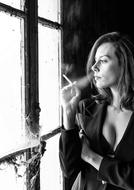 Portrait of Thoughtful Woman smoking at window