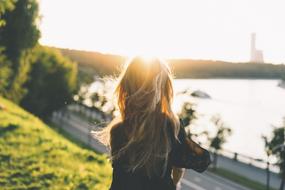 long hair Woman in park at sunset