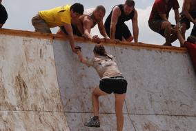 men helping to Girl on Mud Run