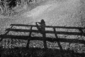 shadow of a stretching woman on the bridge rail