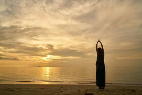 Silhouette of a model on the beautiful, sandy beach at colorful sunset