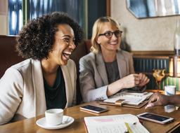 happy African American and caucasian girls in office