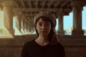 photo of a romantic girl in a beret under the bridge