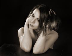 Black and white portrait of the girl in thoughtfulness, at black background