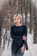 woman in black dress in winter forest