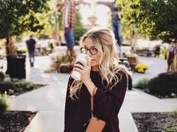 Beautiful girl with drink in plastic cup in park