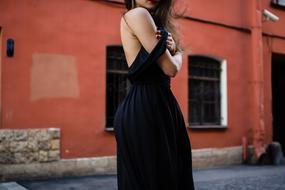female model in black Dress posing on street