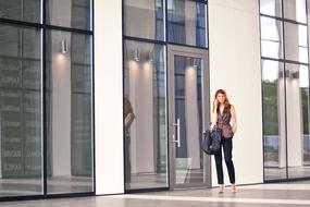 stylish Woman talking On The Phone at glass door