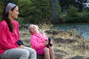 happy Mother and child Daughter sitting at water