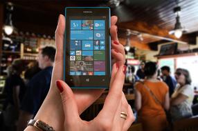 smartphone in female hands in bar