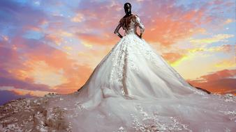 Dummy in the giant wedding dress at colorful evening sky