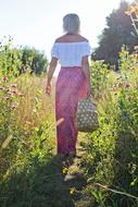 girl walking in a meadow among green grass