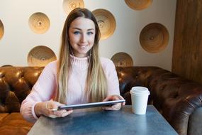 cheerful Young Girl with tablet in cafe