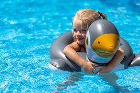 happy child girl with toy in Swimming Pool