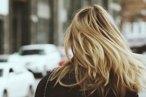 Back view of the blonde woman, near the colorful cars