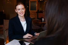 Business Lady at laptop computer communicating with woman