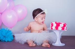 happy asian Baby girl looking at Cake