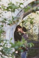 young Couple kissing beneath arch