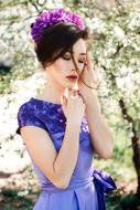 beautiful woman in flower wreath in summer garden