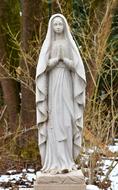 Holy virgin, sculpture on cemetery at winter