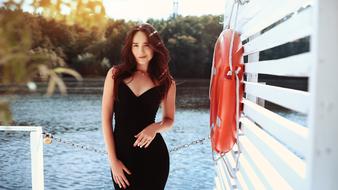 Girl in the black dress posing on the pier