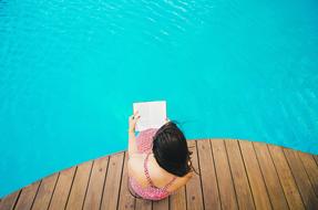 woman reading at water
