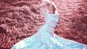 Girl in colorful dress, posing on the beautiful, red grass