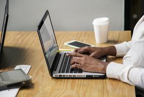 hands of african Businesswoman on keys of laptop