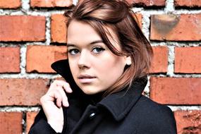 portrait of a young woman on the brick wall background