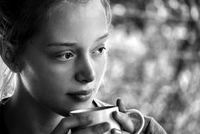 Young girl drinks from mug, Black And white Portrait