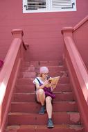 tourist sitting on the pink stairs