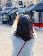 Woman taking photo with Smartphone in city