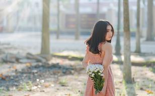photo of a girl with a bouquet behind her back