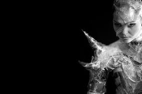 Black and white portrait of a girl in costume, at black background