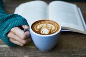 cup of cappuccino and an open book