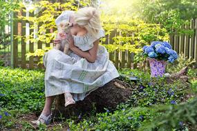 Woman in white dress with the cute and beautiful dog among the colorful plants