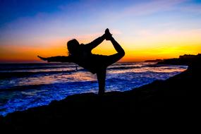 silhouette of a woman on the beach during sunset