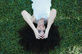 brunette lies on green grass