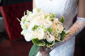 the bride holds a bouquet of white roses