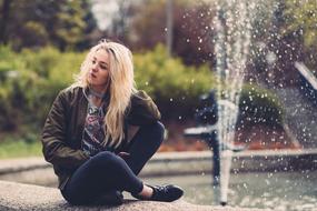 young Girl sits at fountain