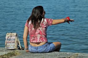 back view of Girl pointing at water