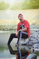 young man sitting by the river