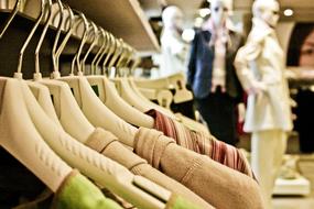 photo of clothes on hangers and manikins in a store