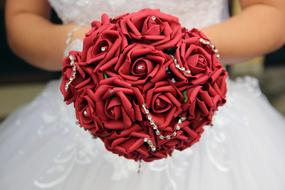 bridal bouquet of red roses in the hands of the bride